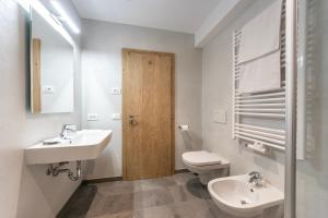 Un baño con lavabo, inodoro y espejo. en Alfred Ties Apartments, en San Vigilio Di Marebbe 37 fotos más