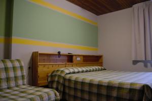 a bedroom with two beds and a rainbow on the wall at Hotel Valdotain in Villeneuve