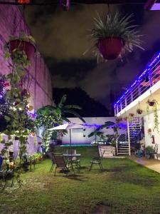 un patio nocturno con sillas y luces púrpuras en Grand Hostal Playa, en Playa del Carmen