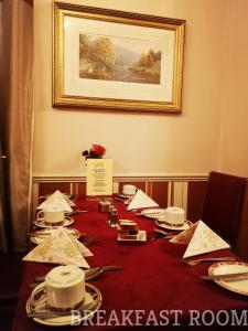 a long table with a red table cloth and plates on it at Westgate Hotel in Oxford