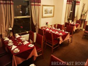 uma sala de jantar com mesas e cadeiras com toalha de mesa vermelha em Westgate Hotel em Oxford