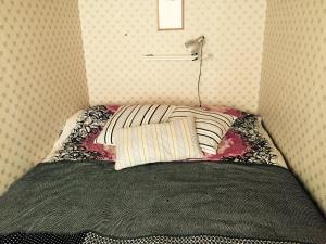 a bed with a pillow and a lamp in a room at Citymökki in Kristinestad