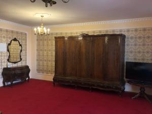 ein Wohnzimmer mit einem großen Holzschrank und einem TV in der Unterkunft Lambach Villa in Mürzzuschlag