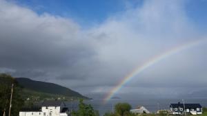 a rainbow in the sky over a body of water at Utsikten Feriehus i Bakkeby in Bakkeby