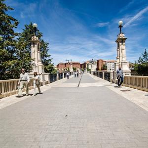 un puente con dos personas caminando sobre él en Fuente Torán Apartamentos, en Teruel