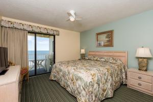 a bedroom with a bed and a balcony at Windy Shores II in Myrtle Beach +63 photos