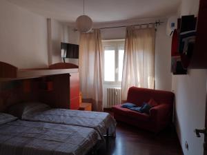 1 dormitorio con 1 cama y 1 silla roja en Checchi House, en Roma