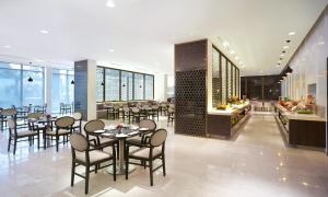 a restaurant with tables and chairs and a buffet at Vivanta Chennai IT Expressway OMR in Chennai