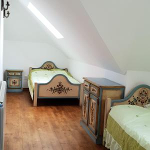 Schlafzimmer im Dachgeschoss mit 2 Betten und einer Kommode in der Unterkunft Casa Tanti Patrita in Slon