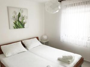 ein Schlafzimmer mit einem Bett mit weißen Laken und einem Fenster in der Unterkunft Vila Virago in Vir