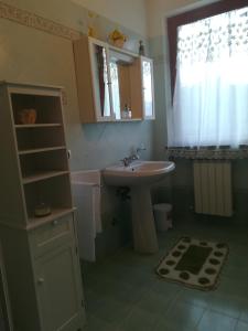 un bagno con lavandino, specchio e finestra di GIARDINO DI PRIMAVERA a Bagnoregio