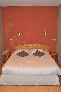 a bedroom with a white bed with two pillows at Hôtel Au Fil de L'Eau in Seyssel