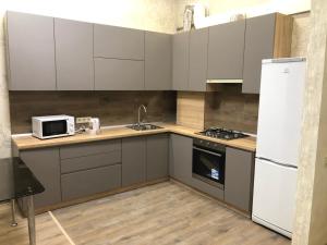 a kitchen with white cabinets and a sink and a microwave at Sartawi.apartment in Sumy