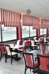 a dining room with tables and chairs in a restaurant at Hôtel Au Fil de L'Eau in Seyssel