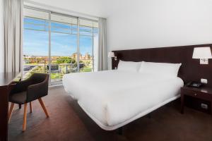 une chambre avec un grand lit blanc et une fenêtre dans l'établissement B&B HOTEL Cantanhede Coimbra, à Cantanhede