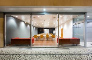 une salle de conférence avec des tables et des chaises dans un bâtiment dans l'établissement B&B HOTEL Cantanhede Coimbra, à Cantanhede