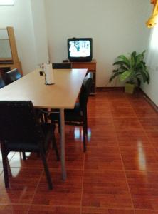 a table with chairs and a television in a room at Departamento Familiar Centro in San Agustín de Valle Fértil