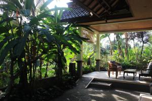 een veranda van een huis met een tafel en stoelen bij Wonder-Land Villa in Ubud