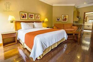 Habitación de hotel con cama y sofá en Hotel San Carlos en Guatemala