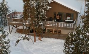 a woman standing on a deck of a house in the snow at House in Breck! Private Hot Tub! Amazing Views! Fireplace! Large Deck! in Breckenridge