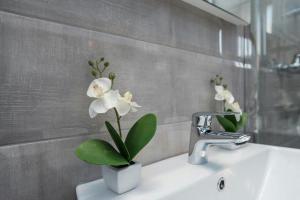 a bathroom sink with a vase of flowers on it at Apartment Maja in Novalja in Novalja +37 photos