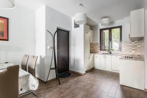 a kitchen with white walls and wooden floors at Keystone Apartments in Donji Morinj