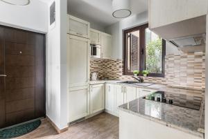 a kitchen with white cabinets and a counter top at Keystone Apartments in Donji Morinj