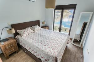 a bedroom with a bed and a large window at Keystone Apartments in Donji Morinj