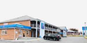 a black car parked in front of a building at Motel 6-Falls Church, VA - Arlington Boulevard in Falls Church