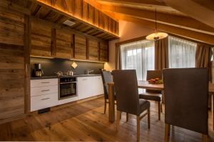 Una cocina con mesa de comedor y sillas. en Lüch dl Cajer - Appartement Gran crëp, en San Martino in Badia