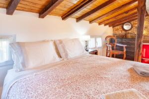 Un dormitorio con una cama grande y una silla. en Loft Caminha, en Caminha