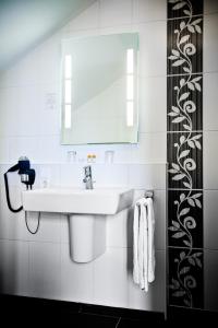 a bathroom with a sink and a mirror at Gasthaus Bürger-Stube in Sasbach am Kaiserstuhl