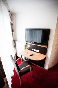 a hotel room with a table and a tv at Gasthaus Bürger-Stube in Sasbach am Kaiserstuhl