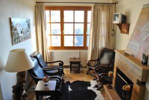 een woonkamer met stoelen, een open haard en een raam bij Ta Dokana in Pinakátai