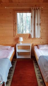 Cabaña de madera con 2 camas y ventana en Ośrodek Wypoczynkowy Nad Brdą, en Tuchola