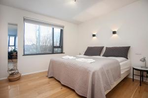 Habitación blanca con cama y ventana en Planet Apartments, en Reikiavik