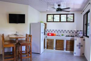 a kitchen with a white refrigerator and a table at Casa Nelly Apartamentos in Sámara