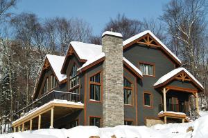 una casa grande con nieve en el techo en Stonehamchalet21 en Stoneham