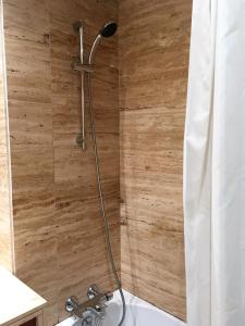 y baño con ducha y pared de madera. en Love Sea Apartment, en Leça da Palmeira
