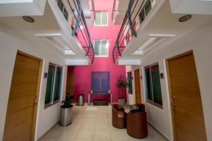 a hallway in a building with pink walls at Hotel Oaxaca Inn Express in Oaxaca City