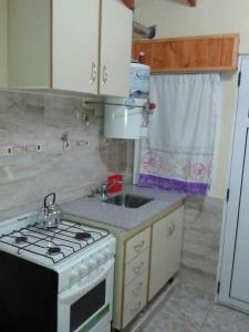 a small kitchen with a stove and a sink at Complejo Extremo in Mar de Ajó