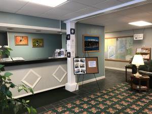 a lobby with a waiting area with a counter and a couch at Baxter Park Inn in Millinocket