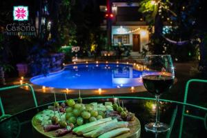 uma mesa com um copo de vinho ao lado de uma piscina em Hotel Boutique La Casona em Axtla
