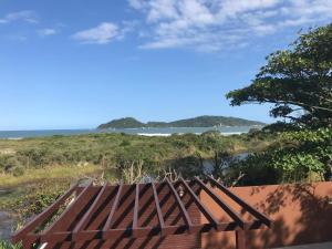 una terraza de madera con vistas al océano en Recanto no Campeche com vista para o mar Apart 08 - 50m da praia -, en Florianópolis