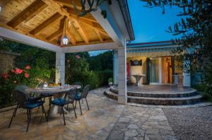 eine Terrasse mit einem Tisch, Stühlen und einem Brunnen in der Unterkunft New modern dream villa 2019 in Kreševo