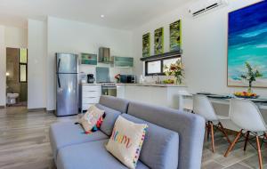 a living room with a blue couch and a kitchen at Casa Reno 1 in Akumal