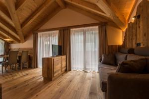 sala de estar con sofá y mesa con TV. en Lüch dl Cajer - Appartement Gran crëp, en San Martino in Badia