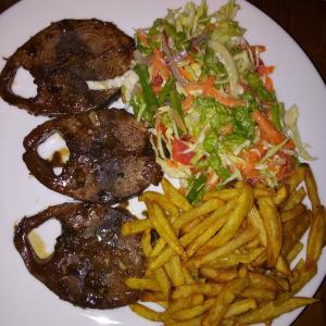a plate of food with french fries and a salad at Methira Villa in Aluthgama