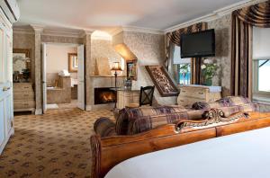 a living room with a bed and a fireplace at Doryman's Oceanfront Inn in Newport Beach