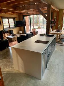 a kitchen with a white island in a living room at The Muddy in Alexandra